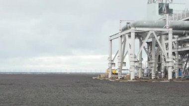 Endüstriyel boru hattı sahil inşa. Büyük petrol rafineri bulutlu sabah denize yakın. Denizde petrol platformu. Yağ tankı sahil ve üretim binası. Video