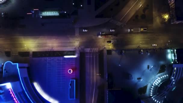 Vista aérea na rua noturna da cidade. Vista superior da intersecção, telhados e ruas iluminadas — Vídeo de Stock