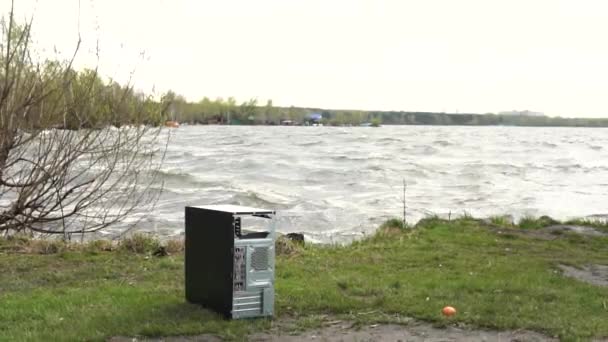 Systemeinheit eines Computers am Flussufer mit Wellenhintergrund. Computer im tropischen Naturpark wie Berg, See und Himmel. Computer auf naturgrünem Hintergrund mit Fluss und Himmel — Stockvideo