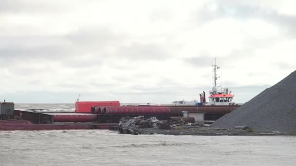 Sun setting at the sea with sailing cargo ship, scenic view. Video. Dark cloudy stormy sky with ship and waves in the sea. Cargo. Tug, floating crane, dry cargo ship, barge and other infrastructure of — Stock Video