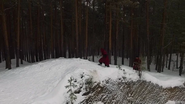 火炬游行。一群僧侣穿着敞篷长袍沿着冬天的雪小径在森林里漫步。镜头。在森林中漫步冬季雪迹的头巾僧团 — 图库照片