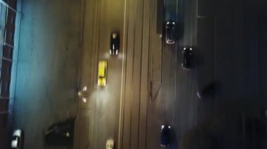 Bir yol sürüş, küçük arabalar ile gece üst aşağı hava dron görünümü. Modern şehir doğru karayolu trafik. Farlar yansıtan. Otoyol üzerinde otoyol trafik havadan görünümü.
