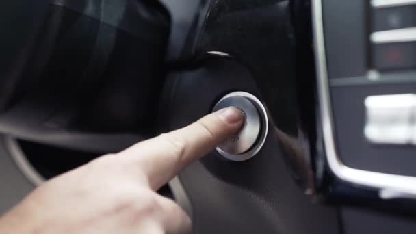 Рука водія натискає кнопку зупинки запуску двигуна. Запас. Сучасні деталі інтер'єру розкішного кросоверу — стокове відео