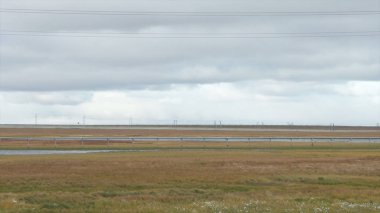 Panorama görüş alanı ve yol ile bulutlu gökyüzü arka plan. Video. Alan ve yol ve dramatik gökyüzü arka plan üzerinde soğuk Sonbahar gökyüzünde ağır gri bulutlar. Yol ve gökyüzü arka plan.