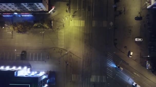 一个空中拍摄的汽车驾驶通过小市中心城市与灯光和十字路口深夜。剪辑。公路空道城市街道夜景鸟瞰图 — 图库视频影像