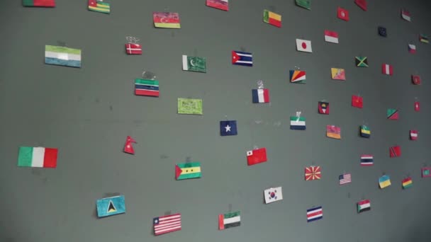 Die Flaggen verschiedener Länder, die an eine Wand gezeichnet wurden. verschiedene Flaggensymbole von Ländern, die an der Wand vereint sind. Clip — Stockvideo