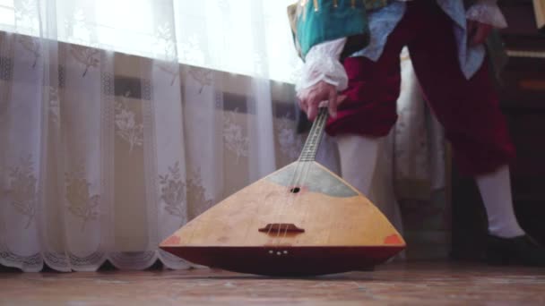 Балалайка дерев'яна в руках музиканта. Запас. Народне музичне мистецтво сільської традиції. Музикант з минулого з Балалайкою — стокове відео