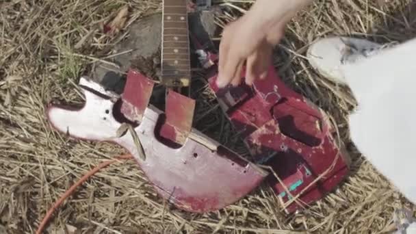 Gebroken gitaar op het gras. Voorraad. Het concept van het vergeten van de klassieke muziek — Stockvideo