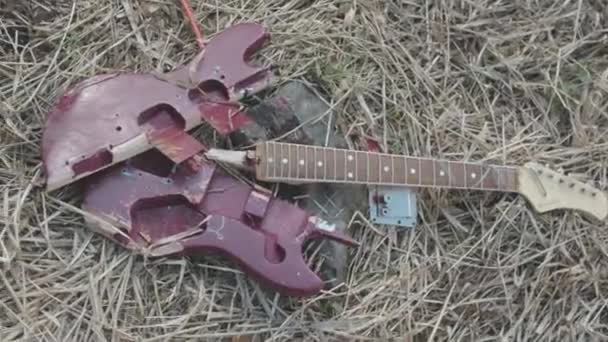 Сломанная гитара на траве. На складе. Концепция забывания классической музыки — стоковое видео
