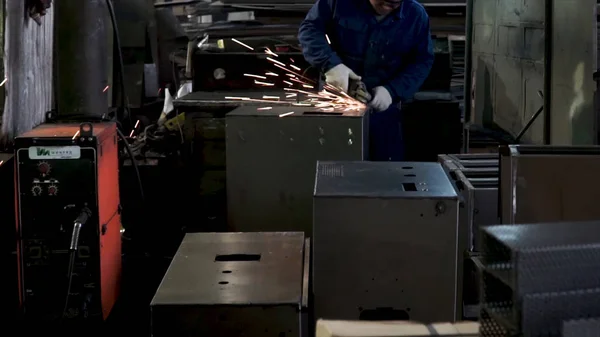 Man grinds a metal sheet. Clip. Grinding machine on work and spark movement in the automotive parts industry — Stock Photo, Image