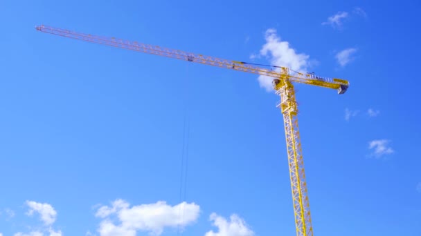 Gépek Daru gyártás, szerszám, az építőipar. A kék ég háttér sárga építőipari daru — Stock videók