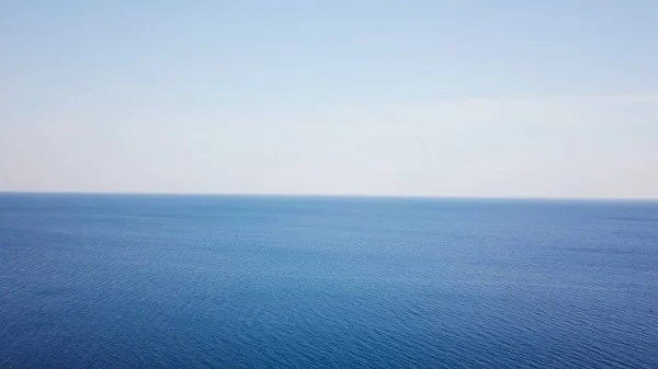 Вид с воздуха Тихий океан и голубое небо фон. Вид на поверхность моря в солнечный день — стоковое фото