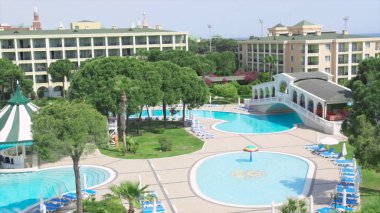 Otel kompleksi ile tropikal muhteşem Yüzme Havuzu. Video. Güneşli bir günde bir pahalı lüks otelin yüzme havuzunda