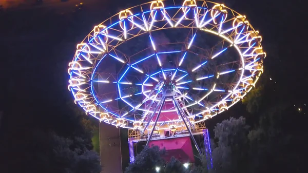 Rueda de la fortuna en un parque de la ciudad por la noche. Clip. Vista superior de la brillante noria por la noche —  Fotos de Stock