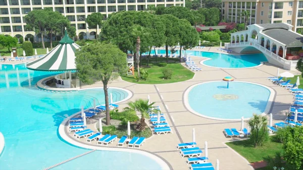 Otel kompleksi ile tropikal muhteşem Yüzme Havuzu. Video. Güneşli bir günde bir pahalı lüks otelin yüzme havuzunda