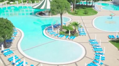 Otel kompleksi ile tropikal muhteşem Yüzme Havuzu. Video. Güneşli bir günde bir pahalı lüks otelin yüzme havuzunda
