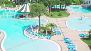 Otel kompleksi ile tropikal muhteşem Yüzme Havuzu. Video. Güneşli bir günde bir pahalı lüks otelin yüzme havuzunda