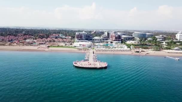 Vista aérea da praia de areia na bela água do mar claro. Vídeo. Vista superior da praia turística à beira-mar — Vídeo de Stock