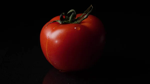 Gotas de agua goteando desde arriba tomates maduros. Una trampa. Primer plano de una gota de agua goteando de un tomate — Foto de Stock