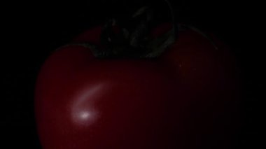 Siyah zemin üzerine kırmızı sulu domates kapatın. Çerçeve. Gıda kavramı