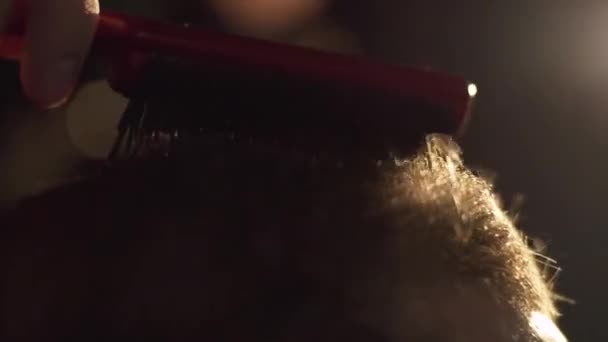 Barber sèche client aux cheveux bruns avec sèche-cheveux. Cadre. Homme peigné et séché avec un sèche-cheveux chez le coiffeur 