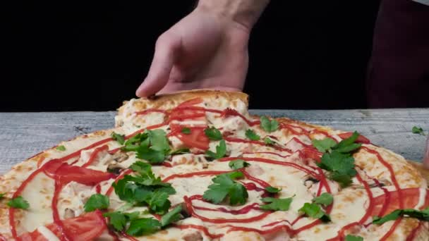 Mann nimmt ein Stück Pizza mit der Hand. Rahmen. Männliche Hand nimmt das Stück Pizza mit Stretchkäse — Stockvideo