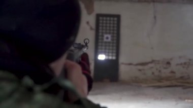 Atış talimi yaparken bir erkek atlet Close-up. Küçük. adam bir tüfeğinden saman bir hedefe yönelik. Ciddi yakışıklı hedefe arıyorsunuz