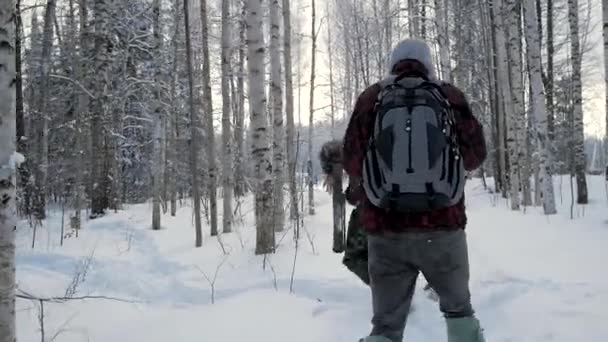 Group of soldiers run on skis in the woods with weapons. Clip. Soldiers with AK-47 rifles and grenade launchers running through the winter forest on skis. Soldiers on exercises in the woods in winter — Stock Video