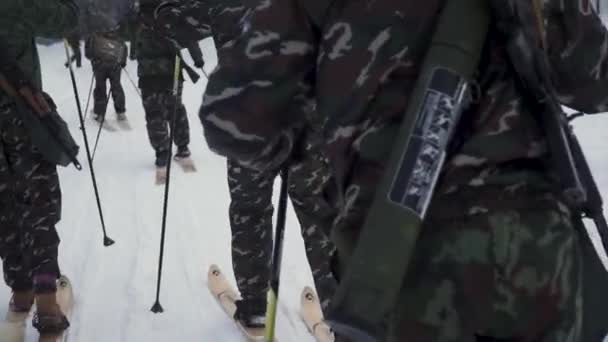 Groep soldaten uitgevoerd op ski's in de bossen met wapens. Clip. Soldaten met Ak-47 geweren en granaatwerpers loopt door het bos van de winter op de Ski's. Soldaten op oefeningen in het bos in de winter — Stockvideo