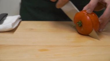 Yarım dilim domates. Küçük. pişirme, gıda ve ev concept - kapat erkek el kesme biber kesme tahtası evde üzerinde. Erkek el kesme domates yakın çekim.