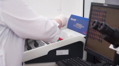 Laboratuvarda test tüpleri kullanarak kadın tıbbi ya da bilimsel araştırmacı. Küçük. Kadın bilim adamı bilgisayarında sıvı kabı ve gözlemler aşağı türlerini inceler. Bir laboratuvarda çalışan Shes