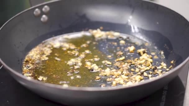 Dans une poêle, faire revenir l'oignon dans l'huile. Clip. Faire revenir les sautés végétariennes. Une saine alimentation. Vue de dessus. Vue de dessus faire revenir les légumes dans un wok, sur la cuisinière 