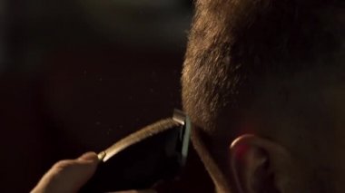 Tarak ve onun işi kesme makinesi ile berber. Çerçeve. Bir saç kesimi saç kesme makineleri ile olan adam. Adam son moda saç kesimi kuaför dükkanında elde kadeh yukarıya kapatmak.