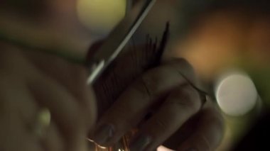 Profesyonel kuaför salon, istemci ile çalışma kapatın. Çerçeve. Salonların bir close-up karanlık bir arka plan ile kırmızı saç kesimini eller. Saç Bakımı, sağlık kavramı