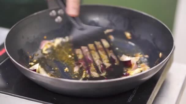 Dans une poêle, faire revenir l'oignon dans l'huile. Clip. Faire revenir les sautés végétariennes. Une saine alimentation. Vue de dessus. Vue de dessus faire revenir les légumes dans un wok, sur la cuisinière 