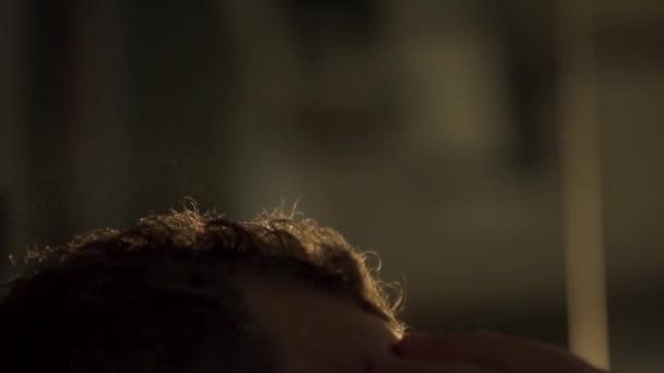 Gros plan de barbier éclaboussures d'eau sur les cheveux des clients au ralenti. Cadre. Coiffeur pulvérisation d'eau et peignage cheveux mouillés. Coiffure masculine dans le salon. Coiffure d'homme. Gros plan sur la coupe de cheveux du coiffeur. Barbier 