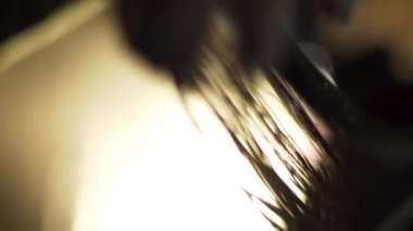 Profesyonel kuaför salon, istemci ile çalışma kapatın. Çerçeve. Salonların bir close-up karanlık bir arka plan ile kırmızı saç kesimini eller. Saç Bakımı, sağlık kavramı