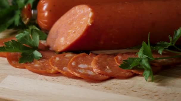 Sliced pepperoni sausages on wooden cutting board. Frame. detail of sliced pepperoni sausages on wooden cutting board. Chorizo salami sausage on rustic background. Meat cold cuts. — Stock Video