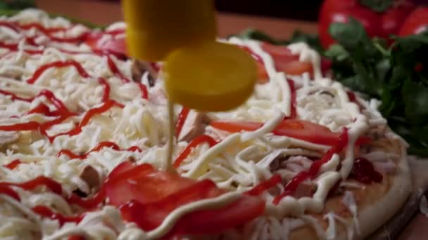 Handen een pizza bereiden. Frame. Koken in de keuken zetten de ingrediënten op de pizza. Pizza concept. Productie en levering van voedsel. Closeup hand van chef-kok in het witte uniform maken pizza bij Bakker — Stockvideo