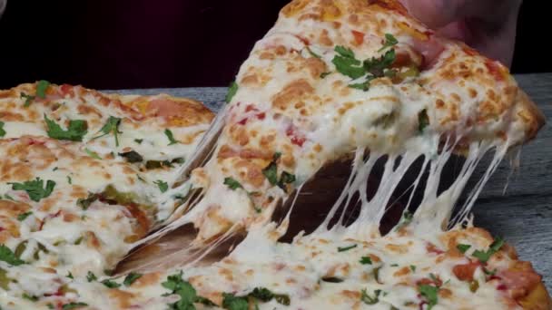 Час прийому їжі в піцерії, чоловік бере шматочок піци з дуже тонкою глибиною різкості. Рамка. Рука нарізає шматочок піци і бере її, крупним планом, макро-стрічкою. Піца і скибочка піци в руці на — стокове відео