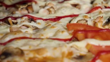 Pizza kapatın. Çerçeve. Pizza bir plaka üzerinde iplik. Pizza arka plan. Siyah zeytin, sosis, salam ve peynir ile büyük İtalyan pizza görünümü kapatın