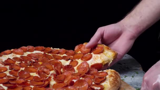 Pizzacıda yemek zamanı, adam pizzadan bir dilim alıyor ve çok ince bir alan derinliğinde. Çerçeve. Elle kesilmiş pizza dilimi ve al, yakın çekim, makro çekim. Pizza ve pizza ellerindeydi. — Stok video
