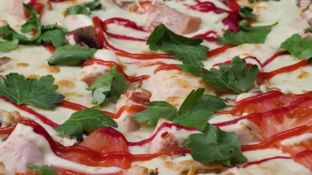 Feche a pizza. Moldura. Pizza a girar num prato. Pizza de fundo. Grande pizza italiana com azeitonas pretas, bacon, salame e queijo vista de perto — Vídeo de Stock