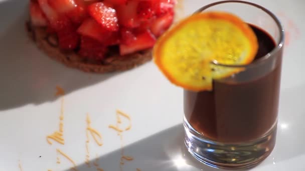 La mano femenina pone la grosella en el plato. Escena. Placa con deliciosas bayas y bebida — Vídeos de Stock