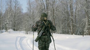 Grup asker kayaklar ormanda silahlarla çalıştırın. Küçük. Ak-47 tüfek ve bombaatar kış orman kayaklar üzerinde çalışan askerler. Askerler kış ormanda egzersizleri üzerinde