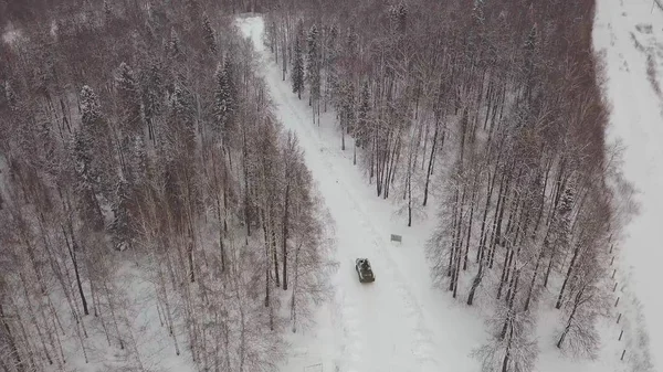 Luftaufnahme einer Panzerfahrt durch den Winterwald. Kampfpanzer im Wald. Tank unter dem Schnee — Stockfoto