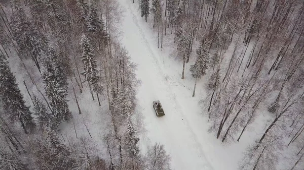 冬の森を運転しているタンクの空撮。森の中戦車。雪の中戦車 — ストック写真