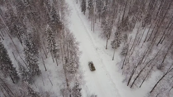 冬の森を運転しているタンクの空撮。森の中戦車。雪の中戦車 — ストック写真