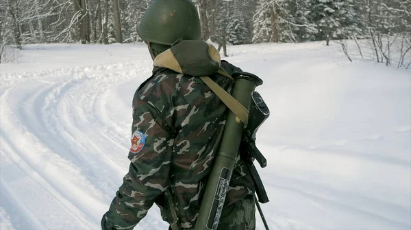 Voják se zbraněmi v chladné doménové struktuře. Zimní války a vojenské koncepce. Klip. Vojáci v zimním lese na lyžích se zbraněmi. Vojenské cvičení v lese v pomalém pohybu — Stock fotografie