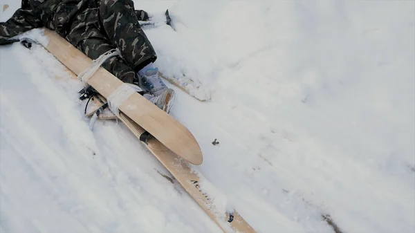 Skidåkare efter olycka väntar på räddning liggande i snön. Klipp. Professionell skidåkare efter krasch olycka skidåkning resort sluttning - vinter sport akut koncept. Ski patrol team rädda skadade skidåkare med — Stockfoto